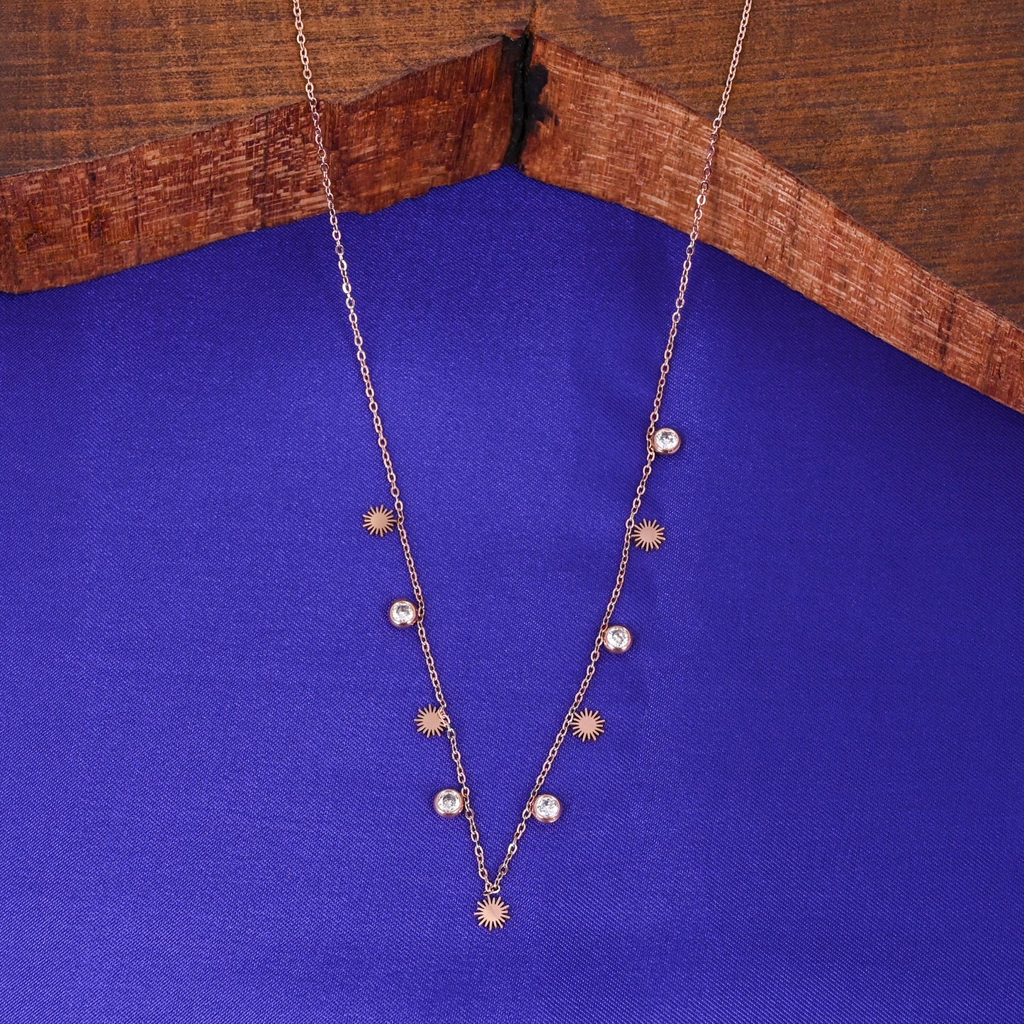 CKLAKART's Rose Gold Charm Neckpiece with White Drop Charms and Luminous Sun