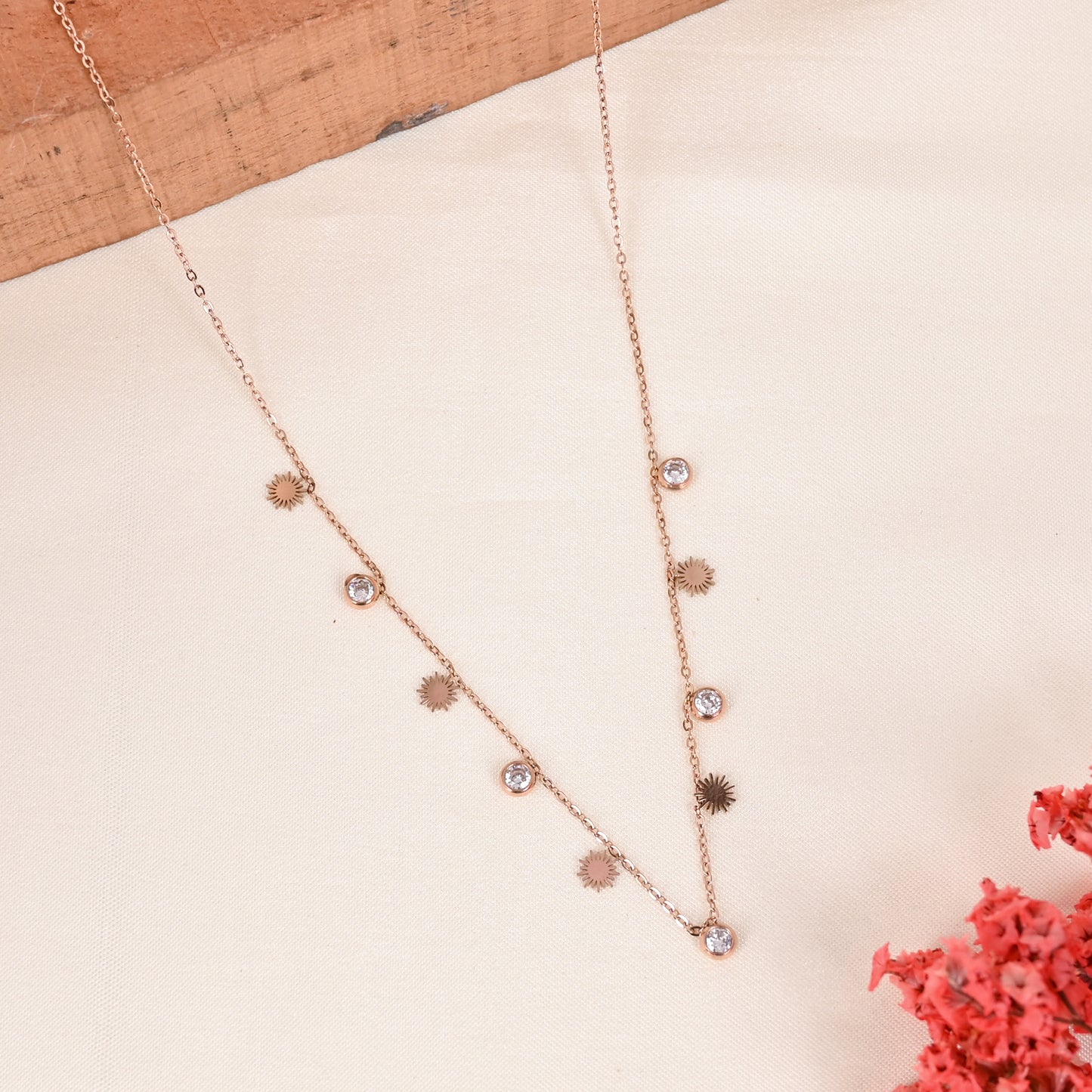 CKLAKART's Rose Gold Charm Neckpiece with White Drop Charms and Luminous Sun