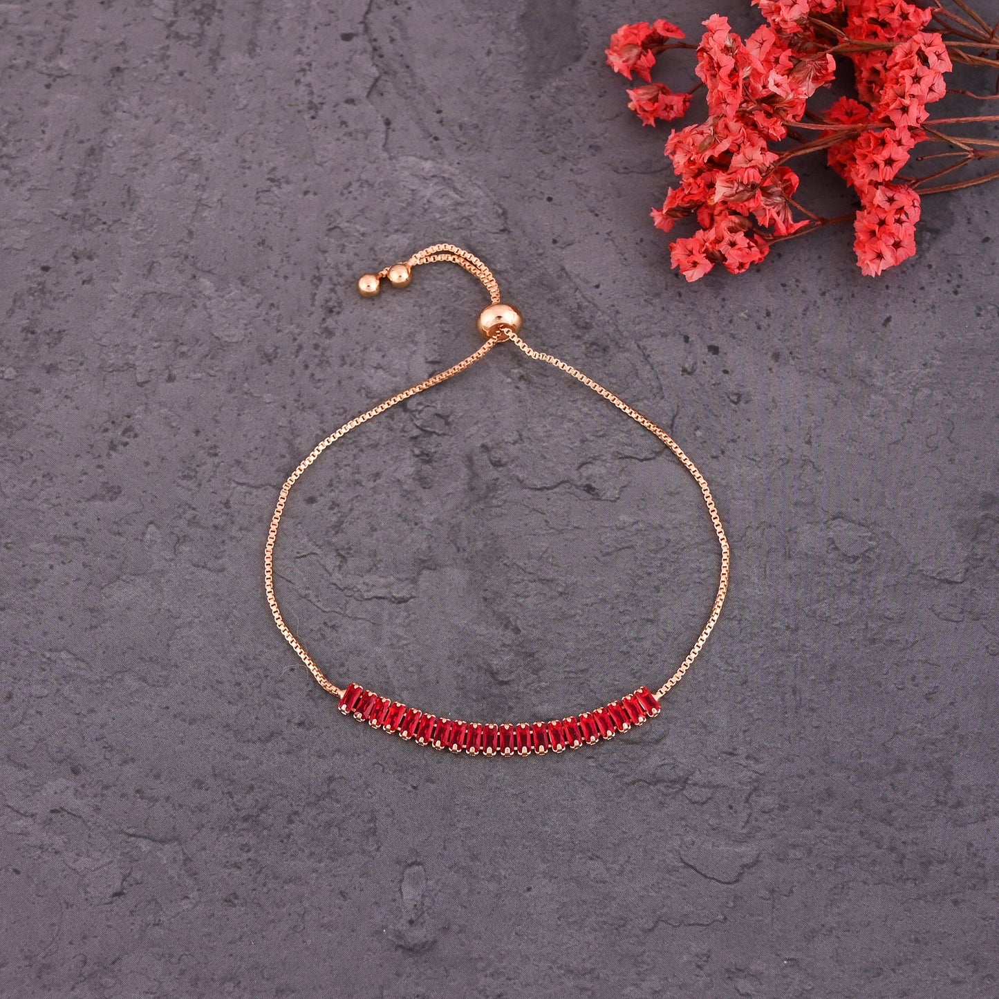 CKLAKART's Gold Toned Bracelet Adorned with Dazzling Ruby Red Stones