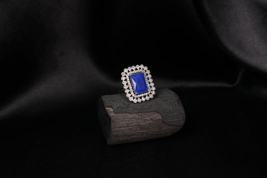 CKLAKART's Silver-Toned Statement Ring with Blue Sapphire Center and White Stone Embellishments