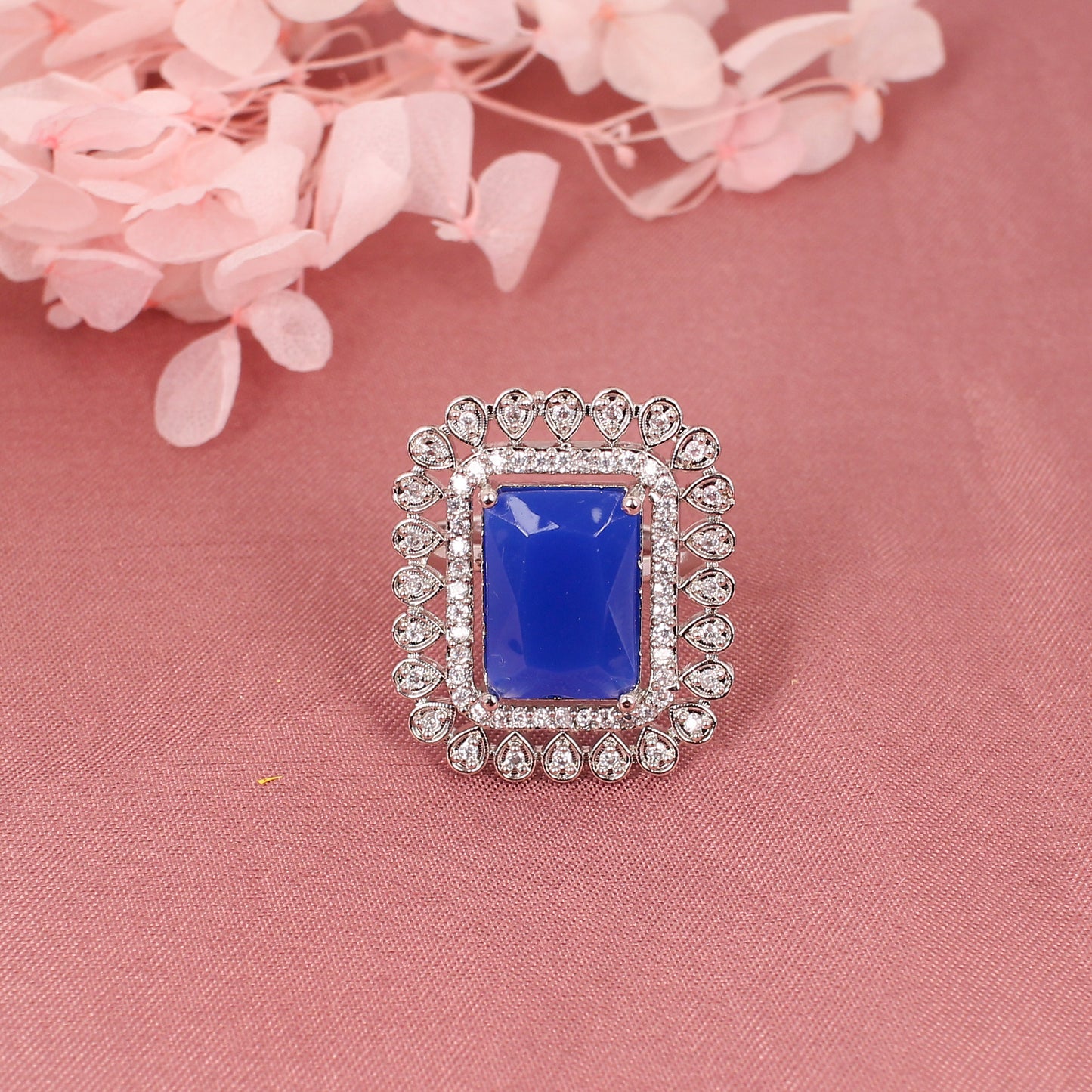 CKLAKART's Silver-Toned Statement Ring with Blue Sapphire Center and White Stone Embellishments