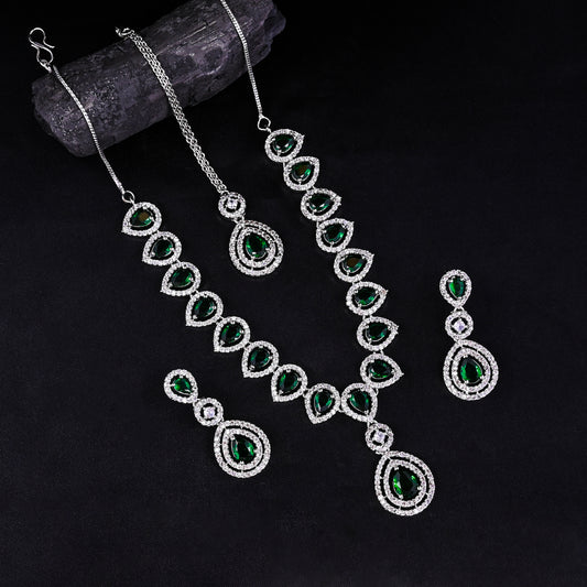 CKLAKART's NOOR Silver-Toned Necklace and Maang Tika Set Adorned with Emerald Green Stones and Dazzling American Diamonds